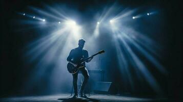 guitariste en jouant sur étape illuminé par projecteur photo