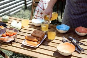 jeune homme préparant une table pour un dîner en plein air photo