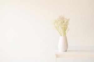 fleurs de gypsophile blanc dans un vase blanc sur la table, style minimal photo