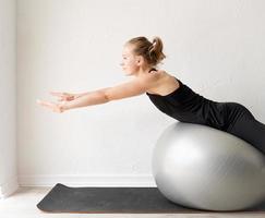 jeune femme sportive assise sur le ballon de fitness photo