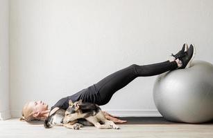 jeune femme sportive sur le ballon de fitness s'échauffant avant l'entraînement photo