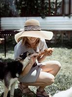 femme griller de la viande à l'extérieur dans l'arrière-cour, assise avec son chien photo