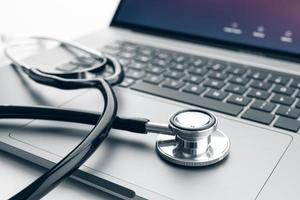 stéthoscope sur ordinateur portable moderne. concept de soins de santé en ligne