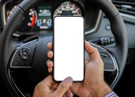main tenant l'écran vide du smartphone tout en conduisant la voiture. photo