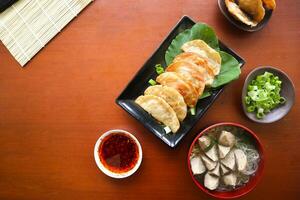 frit wonton. wonton sur assiette avec le Chili huile. crevette ou Viande boulette soupe avec moutarde , vert oignons, sur table photo