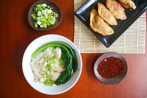 wonton soupe. bol de wonton soupe avec le Chili huile. crevette ou Viande boulette soupe avec moutarde , vert oignons, photo