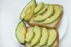 frit pain grillé avec tranches de vert Avocat. une délicieux le déjeuner de pain et mûr Avocat. photo