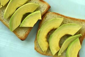 frit pain grillé avec tranches de vert Avocat. une délicieux le déjeuner de pain et mûr Avocat. photo