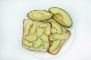 frit pain grillé avec tranches de vert Avocat. une délicieux le déjeuner de pain et mûr Avocat. photo