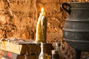 épeler de sorcière nuit avec bougies et pot avec Feu entre toiles d'araignées et ancien Terre photo