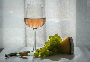 verre de Rose du vin sur le tableau, suivant à vert raisins, difficile fromage, un tire-bouchon avec Liège. fermer, contre-jour photo