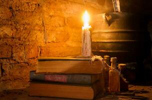 épeler de sorcière nuit avec bougies et pot avec Feu entre toiles d'araignées et ancien Terre photo