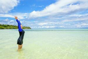 content asiatique adolescent fille jouer éclabousser l'eau dans le mer photo