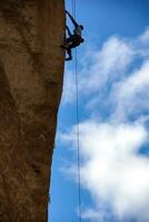 grimpeur sur en surplomb falaise de singe visage photo