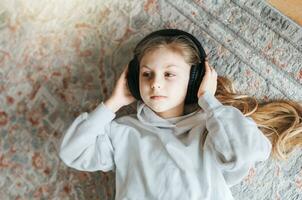 peu fille écoute la musique mensonge sur le sol photo