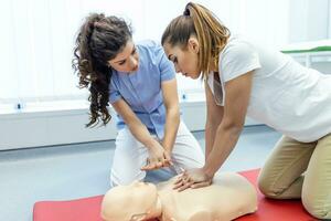 démontrant cpr cardiopulmonaire réanimation formation médical procédure sur cpr poupée dans le classe.docteur et infirmière élèves sont apprentissage Comment à porter secours le patient.d'abord aide pour sûr la vie concept. photo