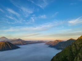 lever du soleil vue de penanjakan 2 ou seruni point au dessous de pouvez être vu le brouillard encore couvertures le mer de le sable et sur le droite côté de le batok Montagne. magnifique la nature Contexte et fond d'écran. photo