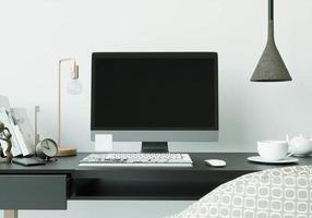 une salle de travail avec un ordinateur posé sur la table photo