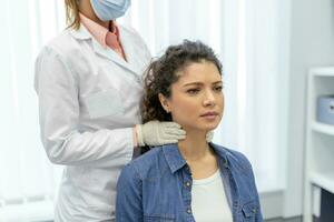 endocrinologue examiner gorge de Jeune femme dans clinique. femmes avec thyroïde glande tester . endocrinologie, les hormones et traitement. inflammation de le endolori gorge photo