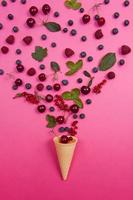 cerise fraîche avec cône gaufré sur fond rose. concept design. photo