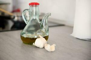 nourriture encore la vie avec une bouteille de Frais supplémentaire vierge olive pétrole et Ail clous de girofle sur le table dans le Accueil cuisine photo