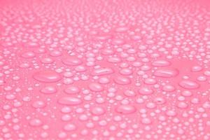 gros plan gouttes d'eau sur fond rose photo