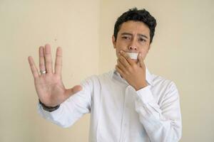 Jeune indonésien frisé homme porter blanc vêtements avec isolé bouche pose. photo