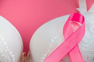 Mois de la sensibilisation au cancer du sein. soutien-gorge pour femme et ruban rose sur fond clair. concept de soins de santé, diagnostic oncologique. photo