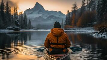homme kayak sur le Lac dans le canadien Rocheuses à lever du soleil. photo