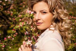 jeune femme romantique dans le jardin de printemps parmi la fleur de pommier. photo