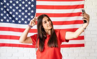 belle femme prenant un selfie sur le fond du drapeau américain photo