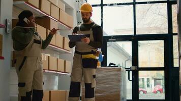 chef la fourniture chaîne officier et employé en train de préparer entrepôt ordres pour livraison, recevoir téléphone appel dans dépôt tandis que balayage Étiquettes sur papier carton des boites colis à être Expédié photo