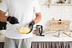 jeune homme faisant de la pâte dans la cuisine photo