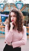 Jeune femme hipster posant à l'extérieur sur le fond des carrousels photo