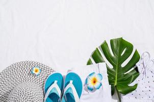 accessoires d'été avec un jean blanc, des chaussures, des feuilles tropicales photo