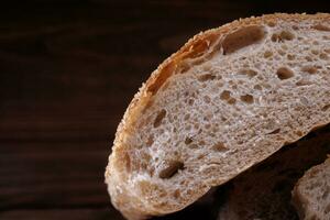 Couper pain de pain une sur une en bois Contexte. pain ciabatta pain. photo