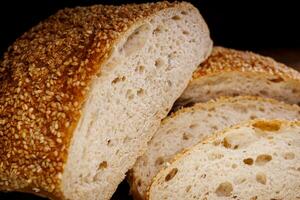Couper pain de pain et pièces de pain sur une en bois Contexte. pain ciabatta pain. photo