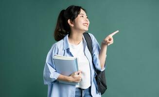 portrait de une magnifique asiatique étudiant sur une vert Contexte photo