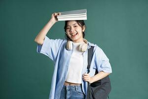 portrait de une magnifique asiatique étudiant sur une vert Contexte photo