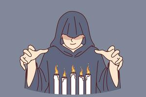 homme moine dans capuche des stands plus de brûlant bougies, performant mystérieux religieux rituel photo