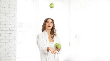 Femme jouant avec pomme verte sur fond blanc photo