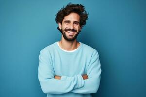 Jeune Beau homme avec barbe portant décontractée chandail et des lunettes plus de bleu Contexte content visage souriant avec franchi bras ai génératif photo