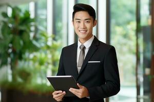 un asiatique affaires homme des stands dans un Bureau travail dans le tablette ai génératif photo