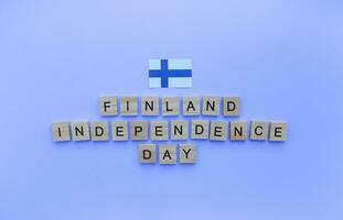 décembre 6, indépendance journée de Finlande, drapeau de Finlande, minimaliste bannière avec le une inscription dans en bois des lettres sur une bleu Contexte photo