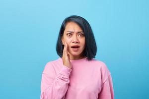femme asiatique choquée avec la bouche ouverte sur fond bleu photo
