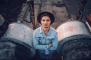 homme avec un chapeau portant une chemise blanche et un jean sur fond de ville photo