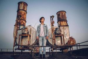 homme avec un chapeau portant une chemise blanche et un jean sur fond de ville photo