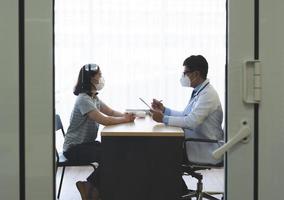 docteur parlant au patient avec des masques dessus photo