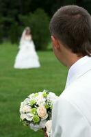 bouquet de blanc des roses dans le mains de le jeune marié photo