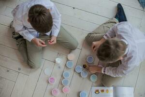 deux frères jouer ensemble. les enfants moule fait maison de raidissement argile. amusement à maison. Facile Les figures de pâte à modeler faire il toi-même. photo